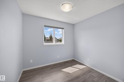 Room featuring wood-finish flooring, a double-pane window, and a flush mount ceiling light fixture - 