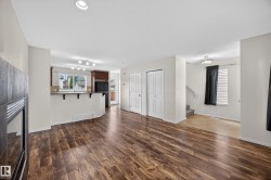 Spacious interior featuring wood-finish flooring, a contemporary fireplace with dark tile surround, and recessed lighting - 
