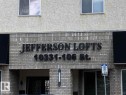 Jefferson Lofts building exterior featuring a gray brick facade and textured stucco finish - 35 10331 106 Street, Edmonton, AB 