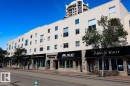 Multi-story commercial and residential building featuring a light-colored stucco facade with multiple windows - 35 10331 106 Street, Edmonton, AB 