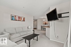 Expansive living area featuring light-colored carpeting and neutral wall tones - 