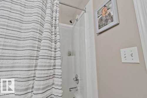 White tile shower surround with chrome fixtures and showerhead - 232 4309 33 Street, Stony Plain, AB 
