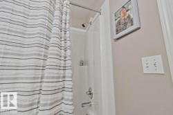White tile shower surround with chrome fixtures and showerhead - 
