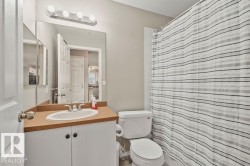 Bathroom featuring a built-in vanity with an integrated sink, a large wall-mounted mirror, and overhead strip lighting - 