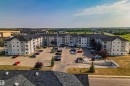 Multi-story residential building featuring light-toned siding and dark shingle roofing - 232 4309 33 Street, Stony Plain, AB 