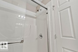 Shower enclosure featuring clear glass sliding doors and a chrome handle - 
