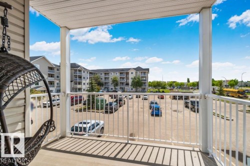 Private balcony with white railing, featuring a neutral-toned floor and a light-colored ceiling - 232 4309 33 Street, Stony Plain, AB 
