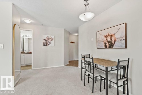 Open-concept room featuring light gray carpeting, white baseboards, and a semi-flush ceiling light fixture - 232 4309 33 Street, Stony Plain, AB 