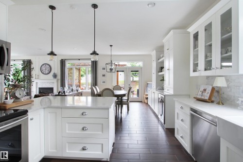 Open-concept kitchen and dining area with dark wood-finish flooring - 34 Falcon Road, Cold Lake, AB 