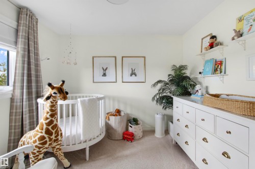 Plush carpet flooring, a window with plaid drapes, and a white dresser with brass hardware - 34 Falcon Road, Cold Lake, AB 