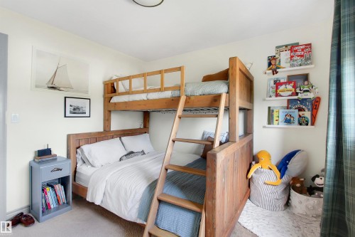 Light-colored walls featuring a natural wood bunk bed with an integrated ladder - 34 Falcon Road, Cold Lake, AB 