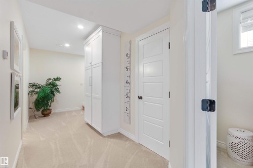 Hallway featuring recessed lighting, light-toned carpeting, white baseboards, and built-in white cabinetry with brushed nickel hardware - 34 Falcon Road, Cold Lake, AB 