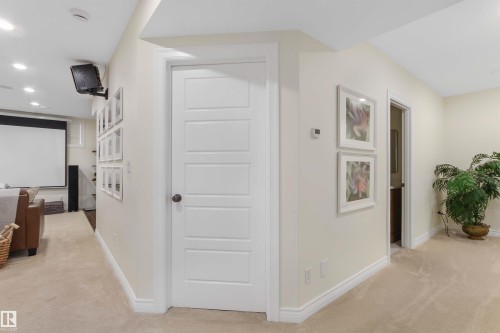 Carpeted hallway with a five-panel interior door, recessed lighting, and white baseboards - 34 Falcon Road, Cold Lake, AB 