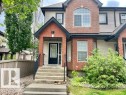 Brick and siding exterior featuring a prominent arched window and a bay window - 1 5281 Terwillegar Boulevard, Edmonton, AB 