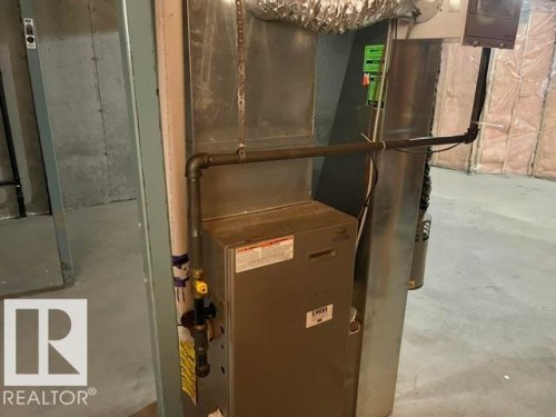 Utility space featuring a forced air unit, metal ductwork, and exposed concrete walls - 1 5281 Terwillegar Boulevard, Edmonton, AB 