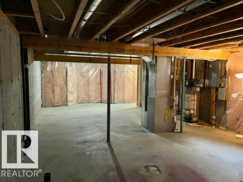 Unfinished basement featuring exposed wood joists, concrete flooring, and insulated perimeter walls - 1 5281 Terwillegar Boulevard, Edmonton, AB 