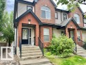Townhome exterior featuring a brick facade with light-toned siding accents - 1 5281 Terwillegar Boulevard, Edmonton, AB 