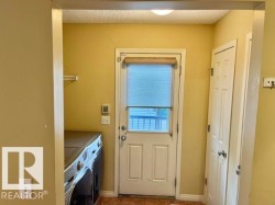 Utility area featuring a rear exterior door with integrated window, a built-in pantry, and overhead wire shelving - 