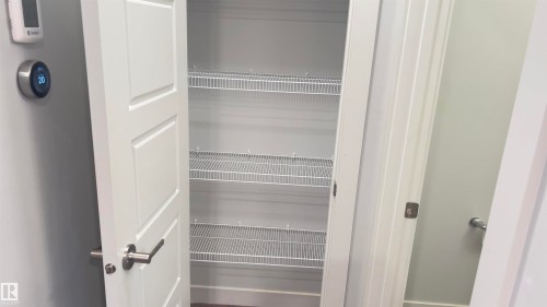 White pantry door with brushed nickel hardware revealing wire shelving - 90 804 Welsh Drive, Edmonton, AB 