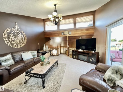 Spacious living area featuring a vaulted ceiling and an ornate chandelier - 11031 166 Avenue, Edmonton, AB 