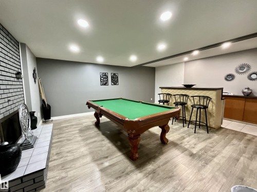 Recreation room featuring wood-finish flooring and a built-in wet bar with a quilted finish - 11031 166 Avenue, Edmonton, AB 