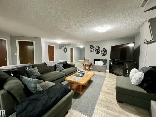 Spacious room featuring light gray walls, wood-finish flooring, and multiple interior doors - 11031 166 Avenue, Edmonton, AB 