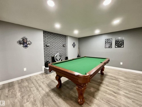 Recreational room featuring a billiards table, wood-finish flooring, recessed lighting, and a decorative brick accent wall - 11031 166 Avenue, Edmonton, AB 
