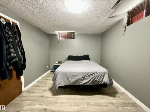 Room featuring wood-finish flooring, light grey walls, and a recessed window - 11031 166 Avenue, Edmonton, AB 