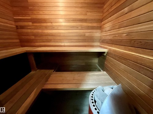 Cedar-lined sauna featuring multi-level wooden benches and a built-in electric heater with stones - 11031 166 Avenue, Edmonton, AB 
