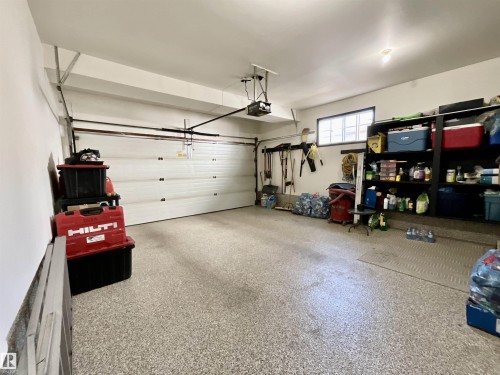 Spacious garage featuring a finished epoxy floor, automatic garage door opener, recessed lighting, and a transom window - 11031 166 Avenue, Edmonton, AB 