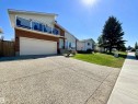 Front exterior featuring brick and siding finishes, an attached garage, and an upper-level balcony with glass railings - 11031 166 Avenue, Edmonton, AB 