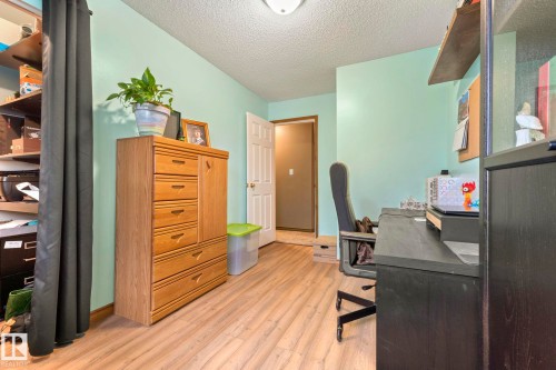 Wood-finish flooring throughout, complemented by light green wall paint and white trim - 9940 83 St, Fort Saskatchewan, AB 