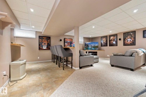 Finished basement featuring a built-in bar, recessed lighting, and carpeted lounge area - 9940 83 St, Fort Saskatchewan, AB 