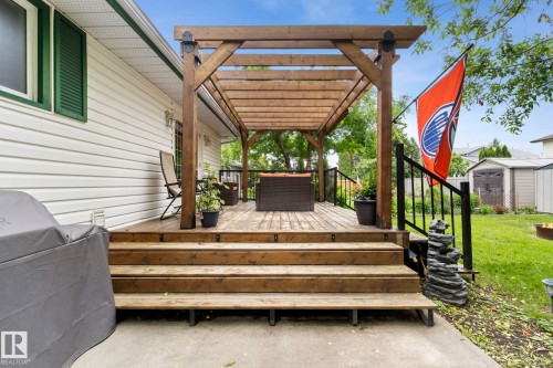 Expansive wooden deck with a built-in pergola structure - 9940 83 St, Fort Saskatchewan, AB 