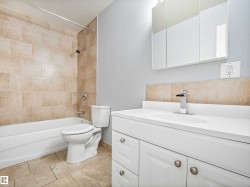Bathroom featuring a white vanity with integrated sink, chrome faucet, and three-panel mirrored medicine cabinet - 