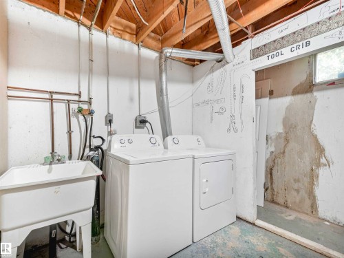 Utility area featuring exposed wood ceiling joists, a white utility sink, and visible plumbing - 13114 30 Street, Edmonton, AB - Indoor Photo Showing Laundry Room