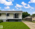 Exterior featuring a white siding finish, a covered balcony with black metal railings, sliding glass doors, a driveway, and a chain link fence - 13114 30 Street, Edmonton, AB  - Outdoor With Deck Patio Veranda 