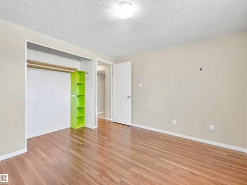 Room featuring wood-finish flooring, light neutral wall paint, and a textured ceiling - 13114 30 Street, Edmonton, AB - Indoor Photo Showing Other Room