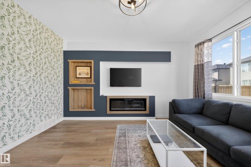 Living area featuring a floor-to-ceiling accent wall with botanical pattern wallpaper - 1684 12 Street, Edmonton, AB 