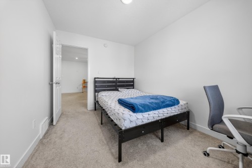 Carpeted room featuring white walls, white trim, and a white interior door - 1684 12 Street, Edmonton, AB 