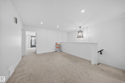 Open upper-level landing featuring light-colored carpeting, white walls, and recessed lighting - 1684 12 Street, Edmonton, AB 