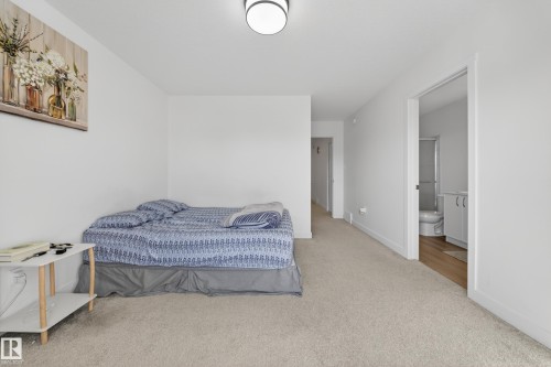 Carpeted room with white walls, featuring a flush-mount ceiling light fixture - 1684 12 Street, Edmonton, AB 