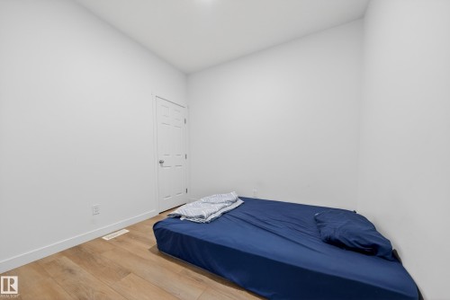 Room featuring light wood-finish flooring, white baseboards, and neutral wall paint - 1684 12 Street, Edmonton, AB 