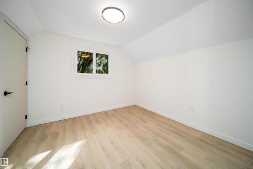 Room featuring wood-finish flooring, white walls, and a recessed window - 10866 92 Street, Edmonton, AB 
