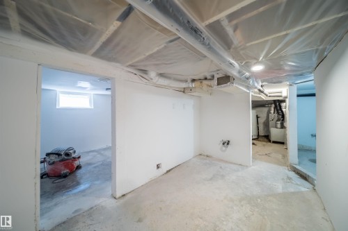 Unfinished basement with concrete flooring, exposed ceiling joists, and white painted walls - 10866 92 Street, Edmonton, AB 