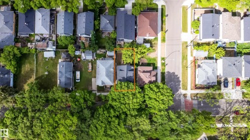 Aerial view showcasing a residential property with a gray gabled roof and surrounding mature trees - 10866 92 Street, Edmonton, AB 