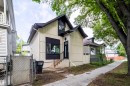 Modern dwelling with a prominent gable roof, light-colored vertical siding, and dark trim accents - 10866 92 Street, Edmonton, AB 