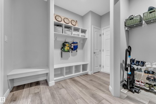 Dedicated mudroom space featuring built-in shelving, hooks, and bench seating - 17551 64 Street, Edmonton, AB 