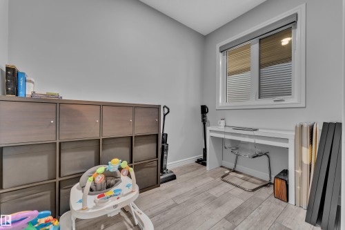 Light gray wall paint with white trim, wood-finish flooring, and a single window with blinds - 17551 64 Street, Edmonton, AB 