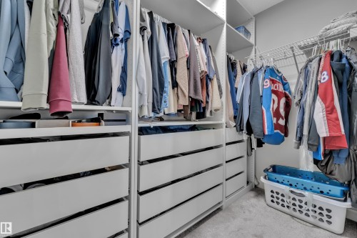 Custom closet system featuring multiple hanging rods, integrated drawer storage, open shelving, and wire shelving - 17551 64 Street, Edmonton, AB 